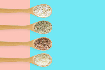 Cereals in a wooden spoon in a row on  pink and turquoise two-tone background.