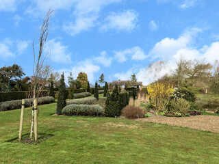 Fototapeta na wymiar Scenic View of a Beautiful English Style Hyde Hall Garden with Green Lawn and blue sky, RHS garden, UK, 17 March 2020