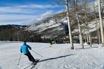 Back view of a man skiing down the slope in Vail Colorado, USA