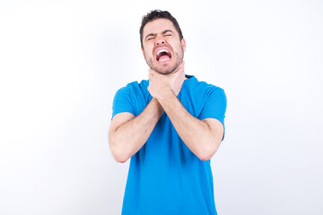 young handsome caucasian man wearing blue t-shirt against white background shouting suffocate because painful strangle. Health problem. Asphyxiate and suicide concept.
