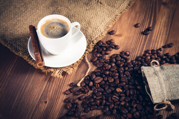 cup of coffee with beans and canvas with cinnamon