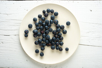 plate with blueberries on whitewashed wooden table
