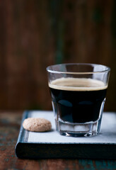 Coffee in glass cup on rustic wooden background. Close up.	