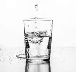 Water being poured into a glass. White background.