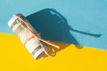 Twisted bundle 100 dollar bills on a yellow background. Business concept