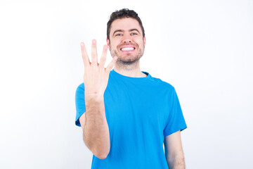 young handsome caucasian man wearing white t-shirt against white background smiling and looking friendly, showing number four or fourth with hand forward, counting down