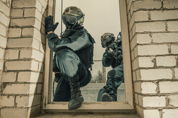 Group of special forces fighters storm the building through the window. Training sessions of the...