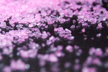 Obraz premium Pink salt on a black stone texture