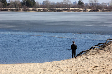 fisherman with a fishing rod on the river bank