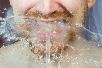 Fototapeta premium Whte man under shower water streams, dynamic face with beard