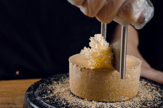 Shaving tete de moine cheese using girolle knife. Variety of Swiss semi-hard cheese made from unpasteurized cows milk, the name Monks head