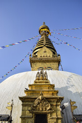 Swayambhunath stupa and prayer flags hanging on it in contrast with the blue sky. Kathmandu, Nepal.