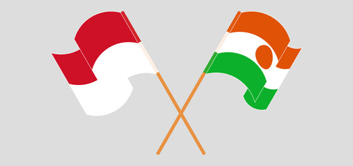 Crossed and waving flags of Indonesia and Niger