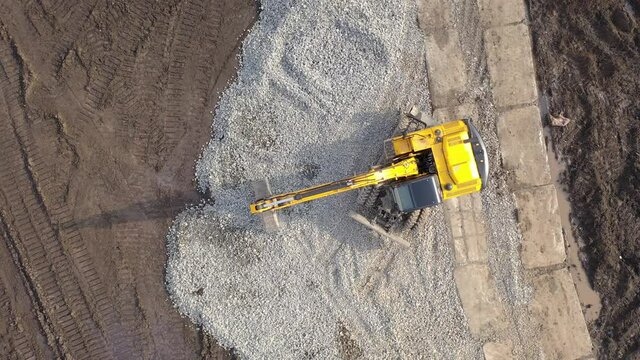Aerial top view on crawler excavator digging ground for overhaul road. Construction machinery performs energy intensive heavy work on project