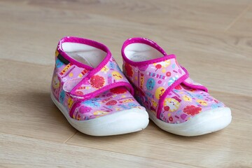 Pink little girl slippers on the floor