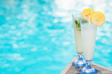 Two tropical cocktails near swimming pool