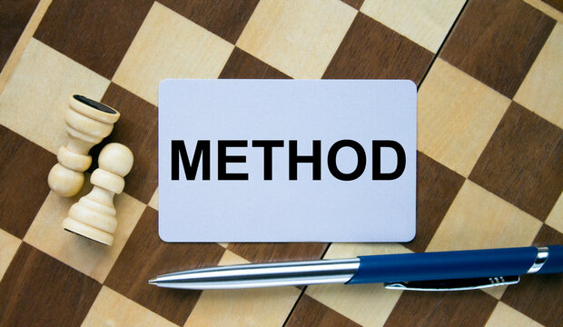 Business card with text Method on a chess board with pen