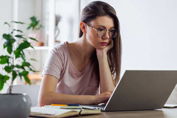 Young woman using laptop to work at home