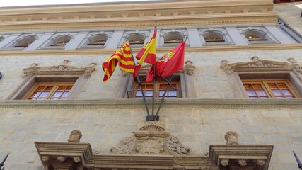 Banderas de España, Aragón y Jaca en la fachada de un edificio público artístico en la ciudad de Jaca, España