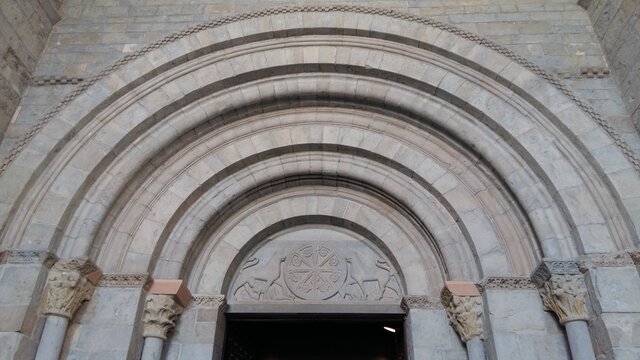 Arcos concéntricos con forma abocinada y tímpano decorado con un cordero místico en una de las portadas más antiguas de la Catedral Románica de Jaca, España