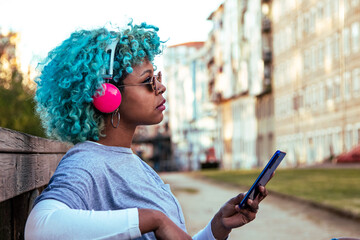 girl with mobile phone and headphones listening to music