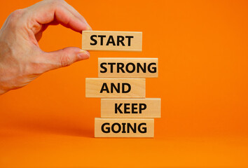 Start strong and keep going symbol. Concept words 'Start strong and keep going' on wooden blocks on a beautiful orange background. Businessman hand. Business, motivational and start strong concept.
