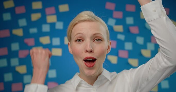 close-up happy young woman dance ad smile, on the background of paper stickers. Office worker was surprised and delighted with news