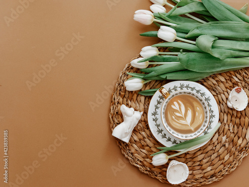 Coffee latte with white tulips , candles on brow background. beautiful breakfast, vintage card, top view, flat lay, 8 march, woman day, mother day, romance