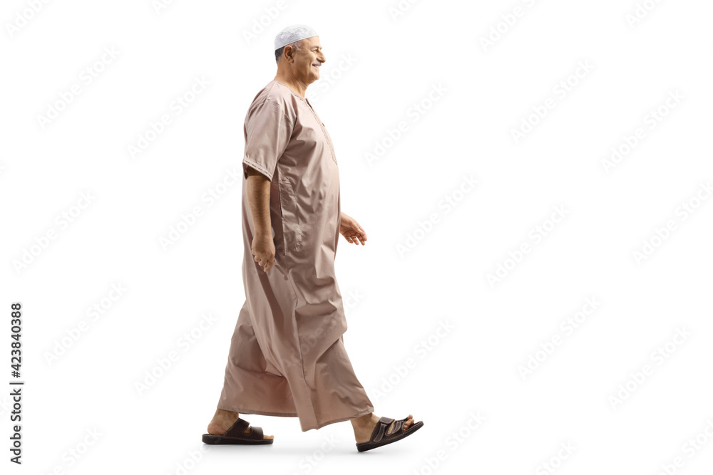 Wall mural full length profile shot of a mature muslim man in traditional clothes walking