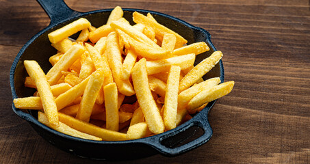 Potato chips inside served in a clay pot on a rustic wooden table
