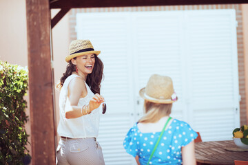 happy stylish mother and child tourists in hats with keys