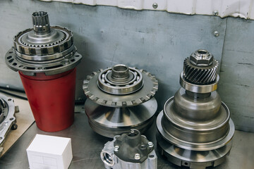 Set of various engine and gearbox spare parts. Shiny gears for planetary gearbox.Metal autotechnology background. wheel engine gears, close up. Automatic transmission in section	