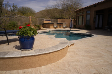 A desert landscaped back yard in Arizona featuring travertine tile.