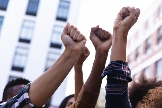 Raised fists of diverse male and female protesters demonstrating on march