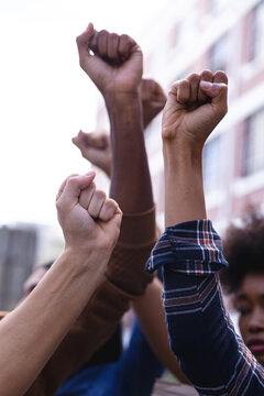Raised fists of diverse male and female protesters demonstrating on march