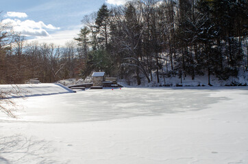 Snow covered dam and frozen over lake at a state park after a blizzard