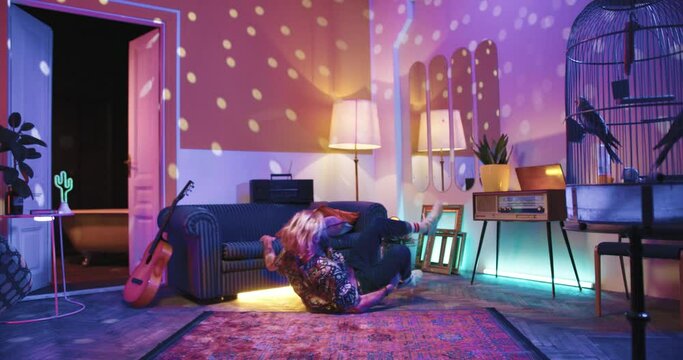 Caucasian Young Stylish Guy In Vintage Living Room At Home Trying To Dance Break Dance And Falling On Floor, Man Dancer Practicing In House, Retro Style, Leisure, Disco Ball Lighting, Parrot In Cage