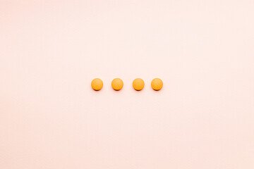 orange pills over pink background. creative medicine and drug concept. pharmacy conceptual. above view. outer space