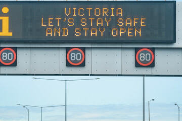 An overhead freeway sign promoting health and safety during the COVID-19 pandemic