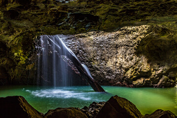 Water flowing through natural arch into underground cave