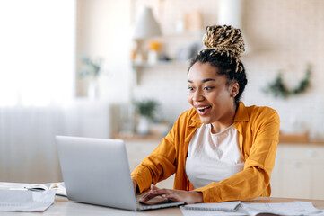 Happy amazed successful young african american woman, manager, freelancer or student working or...