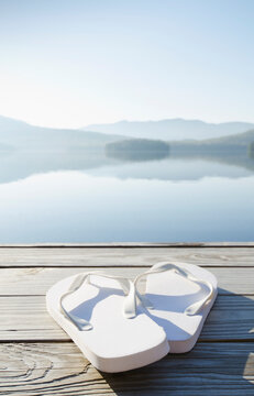 USA, New York, North Elba, Lake Placid, Pair of white sandals on dock