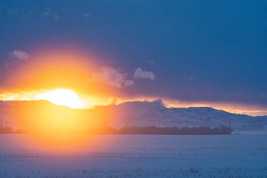 USA, Idaho, Fairfield, Sun setting over mountains and prairie