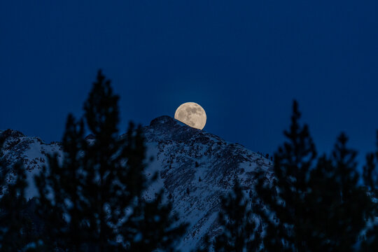 USA, Idaho, Sun Valley, Full moon rising over Boulder Mountains in winter night - Powered by Adobe