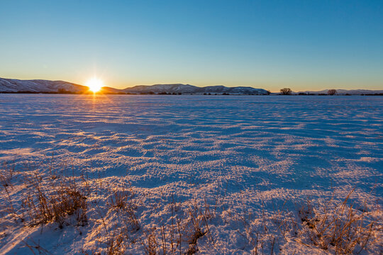 USA, Idaho, Bellevue, Sun setting over snowy field