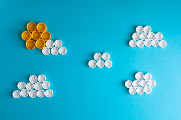 White clouds and the Sun made of plastic bottle caps