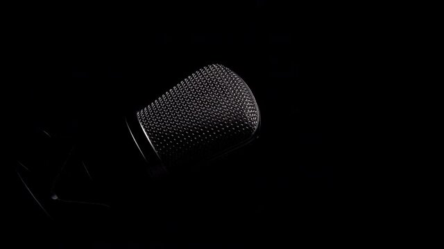 Professional studio microphone on an anti vibration stand, being side lit