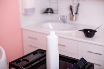 White bottle with hair care shampoo in hairdressing salon
