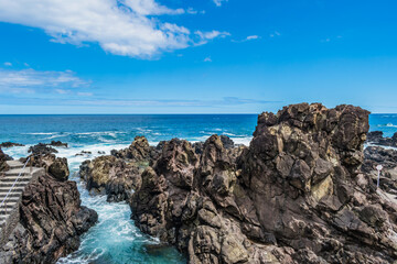 Fototapeta na wymiar Rugged rocks of volcanic eruption that form natural sea pools in Quatro Ribeiras beach, Terceira - Azores PORTUGAL