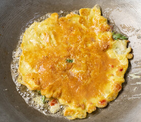 Frying Thai omelette in a pan. Selective focus. Locally know as Kai Chiao.